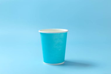 Açık mavi arka planda tek kullanımlık kağıt bardak. Tek kullanımlık sofra takımı. Kavram. Yüksek kalite fotoğraf