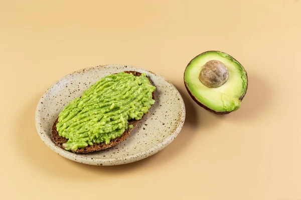 Taze avokado ve çavdar esmer ekmekli sağlıklı bir sandviç. Yarım avokado. Sağlıklı beslenme. Kavram. Yüksek kalite fotoğraf