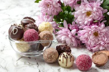 Masada çikolata, şeker ve çiçek var. Yakın plan. Kartpostal Mesajın için yer aç. Yüksek kalite fotoğraf