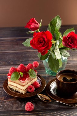 - Pasta. Tabakta bir parça ahududulu kek. Bir fincan kahve. Kutlama yemeği. Vazoda bir buket kırmızı gül. Kartpostal Poster. Yüksek kalite fotoğraf