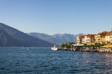 Como Gölü 'ndeki gemi. Bellagio manzaralı. Dağlardaki göl. Dağların yamacındaki şehir. Bulanık bir geçmişi olan güzel bir deniz manzarası. Kart. Poster. Kart. Poster.