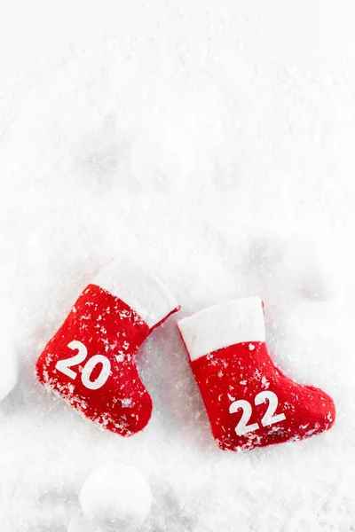 Noel Baba 'nın kırmızı çizmeleri karda. Noel botu. Yeni yıl 2022. Kart. 