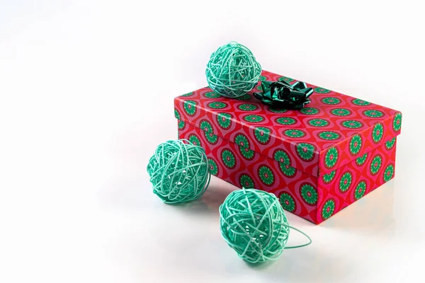 白色背景上的礼物和柳条球。盒子上系着一条绿色的带子.概念。隔离的. — 图库照片