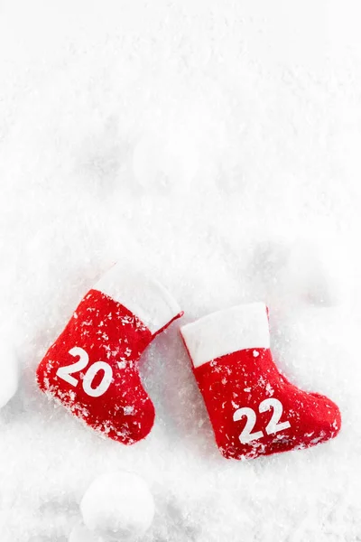 Botas Rojas de Santa Claus en la nieve. Bota de Navidad. Año Nuevo 2022. Tarjeta. Imagen De Stock