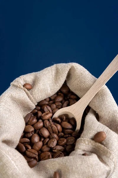 Ziarna kawy w płóciennej torbie na ciemnoniebieskim tle. Pojęcie. — Zdjęcie stockowe