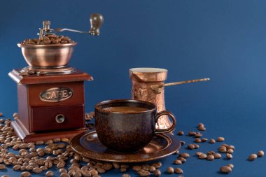 Kahve fincanı, bakır Türk ve kahve öğütücüsüyle mavi arka planda kahve çekirdekleri..