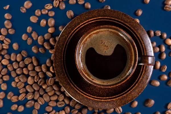 Brązowy kubek z kawą i ziarnem kawy na niebieskim tle. Koncepcja. Układy płaskie. — Zdjęcie stockowe