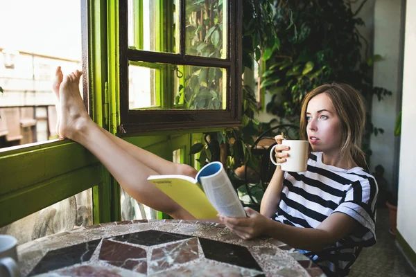 Mujer bebiendo café y leyendo libro — Foto de Stock
