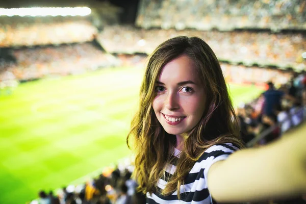 Woman making selfie on football game