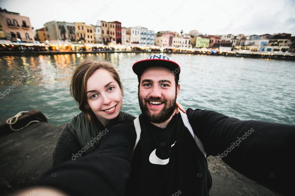 Beautiful couple of tourists take travel selfie