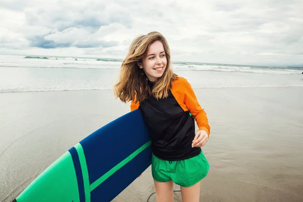 Surfer girl holding surf board