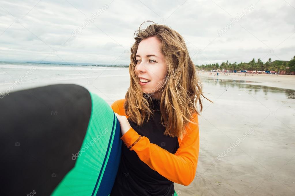 Surfer girl holding surf board