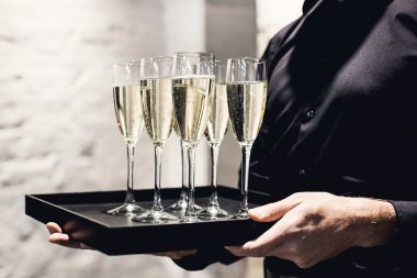 waiter holding glasses with champagne clipart