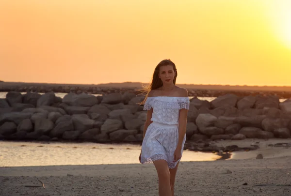 Lány a fehér ruhát a naplementekor — Stock Fotó