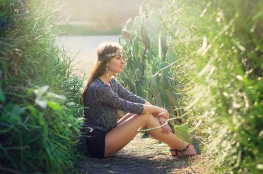 Yerde oturan genç hippi kadın