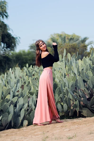 Mladé hippie žena v růžové sukně poblíž oblasti kaktusy — Stock fotografie