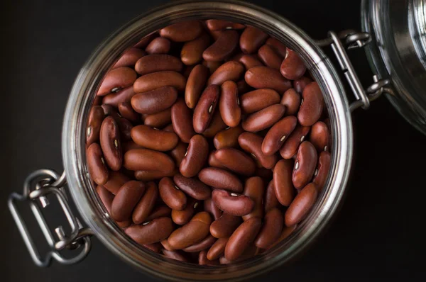 Siyah arka plan üzerine bir cam kavanoza ham fasulye
