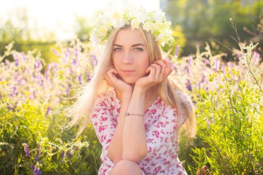 Çiçek taç ile uzun sarı saçlı genç kadın 