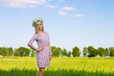 Beyaz çiçek yakınlarında ayakta yapılan taç ile sarışın kız