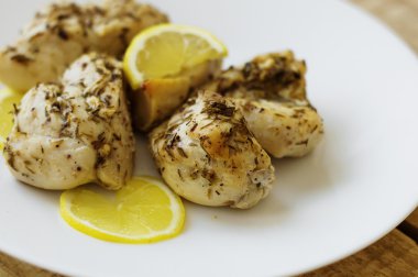 Beyaz Tavuk eti limon ve beyaz tabakta otlar
