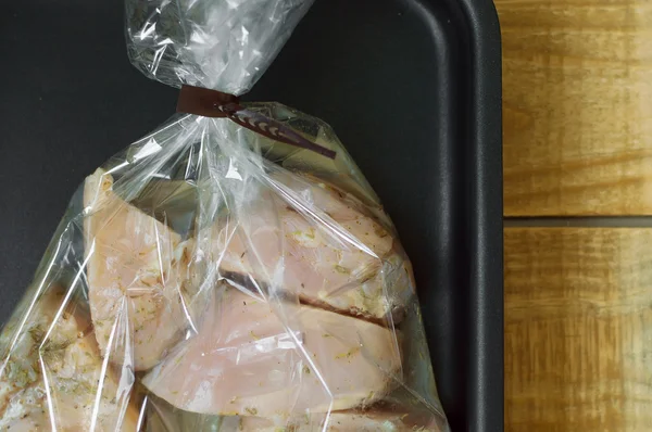 Tranches de poulet cru marinées dans un sac de cuisson. Cooki métal noir — Photo