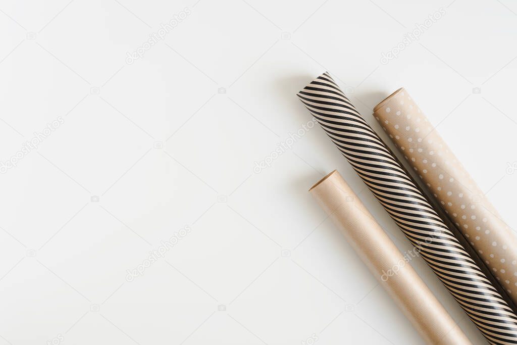 Three gift wrapping paper rolls on white background, top view. Kraft paper for DIY Christmas gift wrapping. Eco friendly packaging