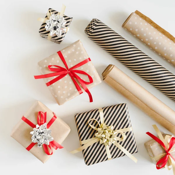 Kraft kağıdına sarılı Noel hediye kutuları ve DIY için kağıt rulo paketler beyaz arka planda, üst görünümde paketlenmiş sunar