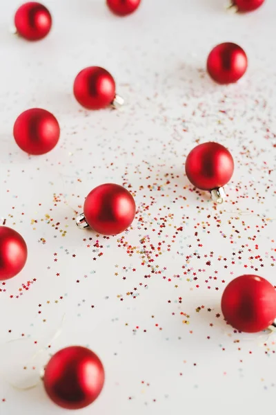 Rode Kleine Decoratieve Kerstballen Kleurrijke Glitters Witte Achtergrond Kerst Nieuwjaarsconcept — Stockfoto
