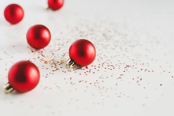 Achtergrond Met Kleine Rode Kerstballen Kleurrijke Glitters Witte Achtergrond — Stockfoto