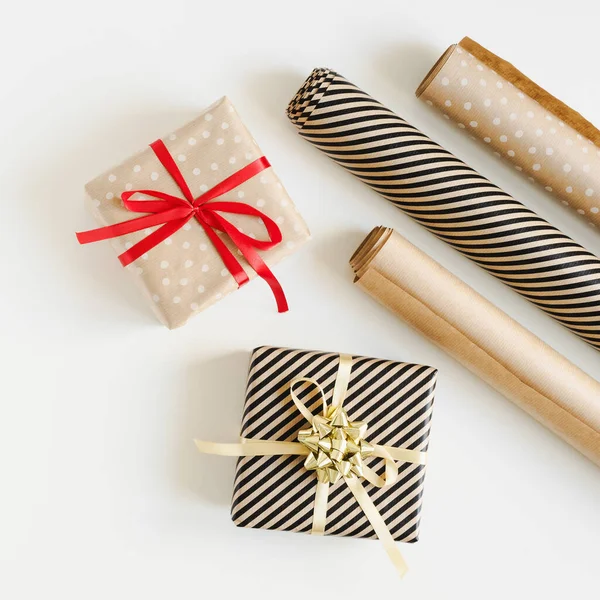 Kahverengi kraft kağıdına sarılı Noel hediyelerinin kare fotoğrafı ve DIY ambalajı için kağıt rulo. Noel hediyeleri