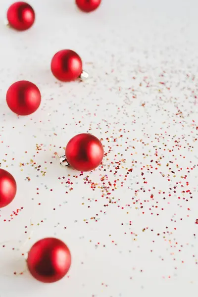 Verticale Achtergrond Met Rode Kerstballen Kleurrijke Stervormige Glitters Witte Tafel — Stockfoto