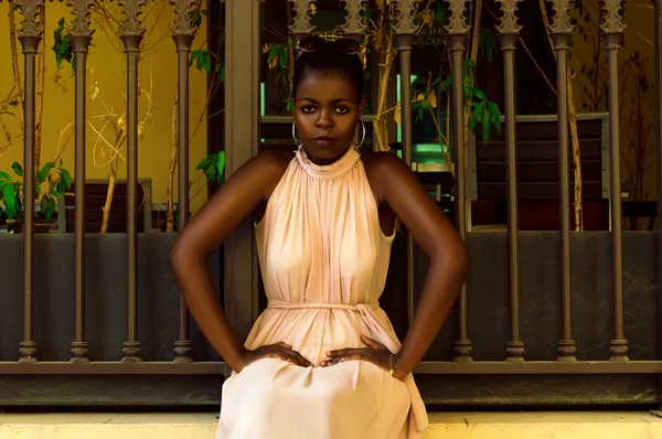 Африканская женщина сидит у забора — стоковое фото