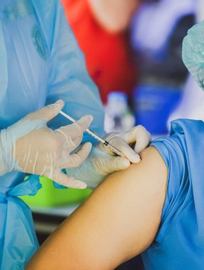 Doktorun hastaya iğne yaparken çekilmiş görüntüsü, covid konsept 