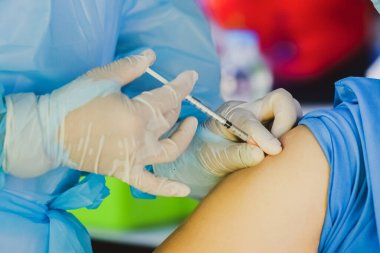 Doktorun hastaya iğne yaparken çekilmiş görüntüsü, covid konsept 
