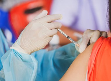 Doktorun hastaya iğne yaparken çekilmiş görüntüsü, covid konsept 