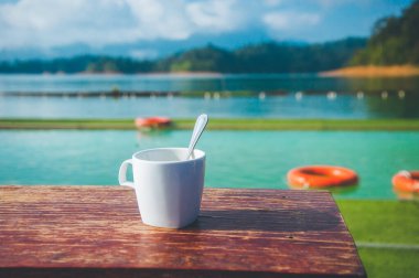 Arka planda doğa olan kahve fincanı