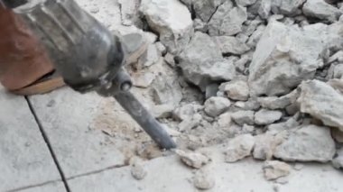 Beton bir duvarın çekiçle yakın plan çekimi.