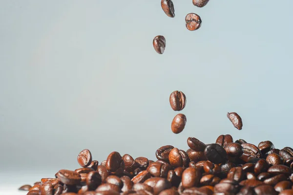 Background picture of roasted coffee beans on a light background.