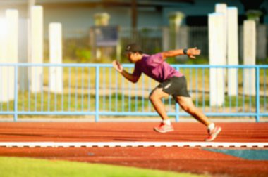 Pistte sıkı çalışan bir koşucunun bulanık lensi. erkek koşucu eğitimi