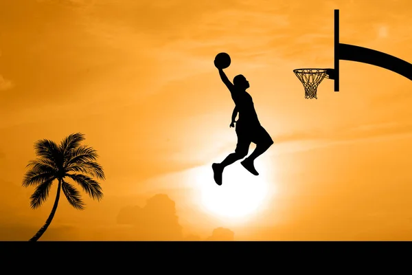 篮球运动员在一个美丽的户外篮球场上跳起扣篮 勾勒出自己的轮廓 — 图库照片