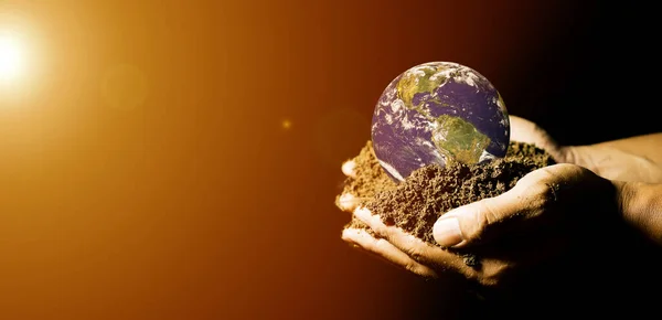 hands holding the earth where the earth is heated by the sun causing global warming. element of the picture is decorated by NASA