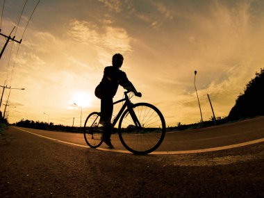 İnsanlar akşamları bisikletle egzersiz yapar. Doğa sporu arka planı. Akşamları arka planda hareket eden bir bisikletçinin görüntüsü