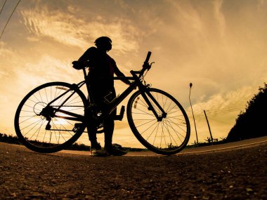 İnsanlar akşamları bisikletle egzersiz yapar. Doğa sporu arka planı. Akşamları arka planda hareket eden bir bisikletçinin görüntüsü