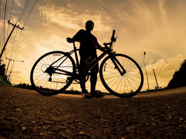 İnsanlar akşamları bisikletle egzersiz yapar. Doğa sporu arka planı. Akşamları arka planda hareket eden bir bisikletçinin görüntüsü