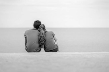 Sahilde oturan çift dikiz aynası, siyah beyaz.