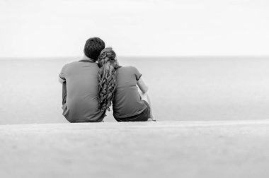 Sahilde oturan çift dikiz aynası, siyah beyaz.