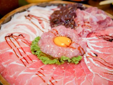 Yumurta sarısı ile servis edilen çeşitli et parçaları.