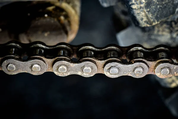 Dirty sprockets and chains show signs of wear and tear.