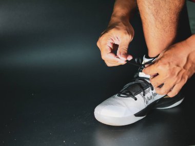 COVID-19 krizinden sonra antrenmana hazırlanmak için ayakkabı askısı bağlayan atletlerin yakın çekimleri.