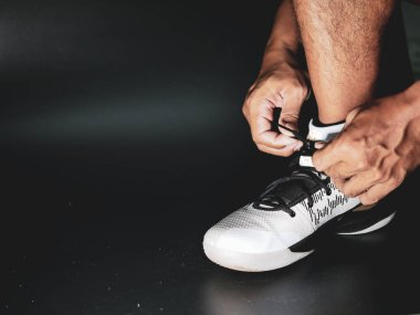 COVID-19 krizinden sonra antrenmana hazırlanmak için ayakkabı askısı bağlayan atletlerin yakın çekimleri.